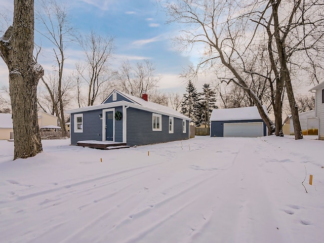 view of front of house featuring an outdoor structure, a garage, and a chimney