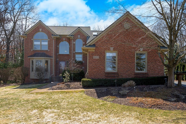 traditional-style home featuring brick siding and a front lawn