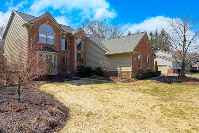 view of front facade featuring brick siding, a front lawn, and roof with shingles