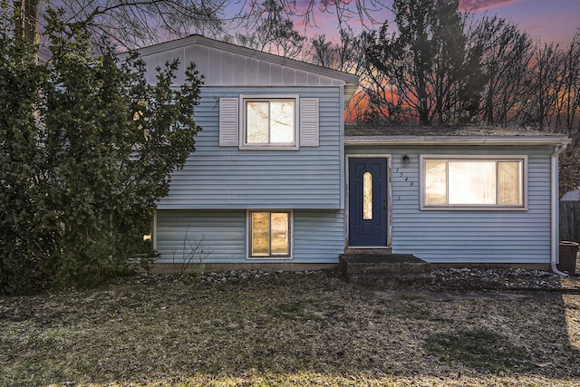 split level home with board and batten siding and entry steps