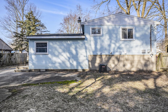 rear view of property with central AC and fence