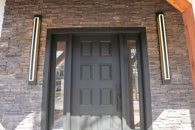 property entrance with stone siding