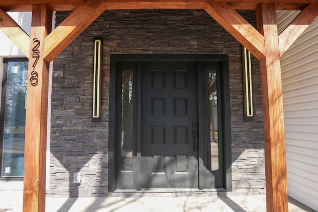 doorway to property featuring stone siding