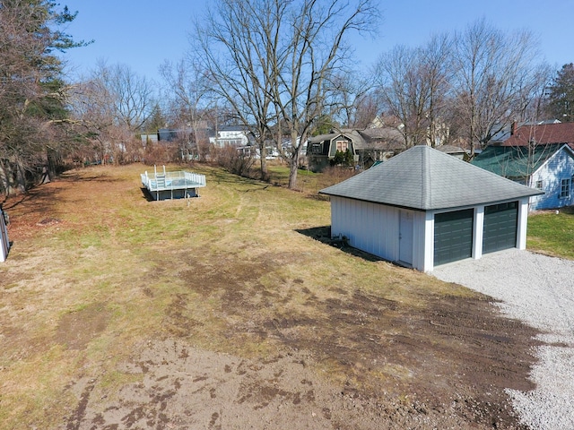 view of yard featuring a detached garage and an outdoor structure