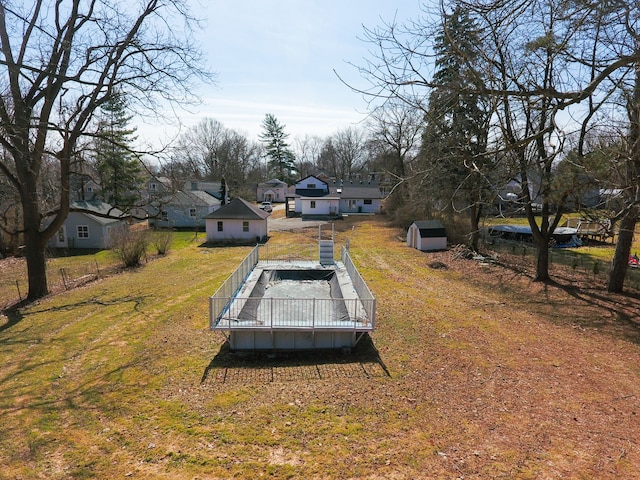 view of yard featuring a deck, fence, an outdoor structure, and a shed