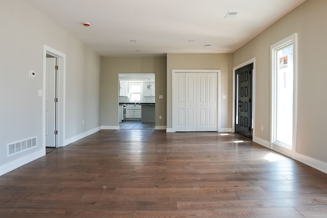 interior space featuring dark wood-style floors, visible vents, and baseboards