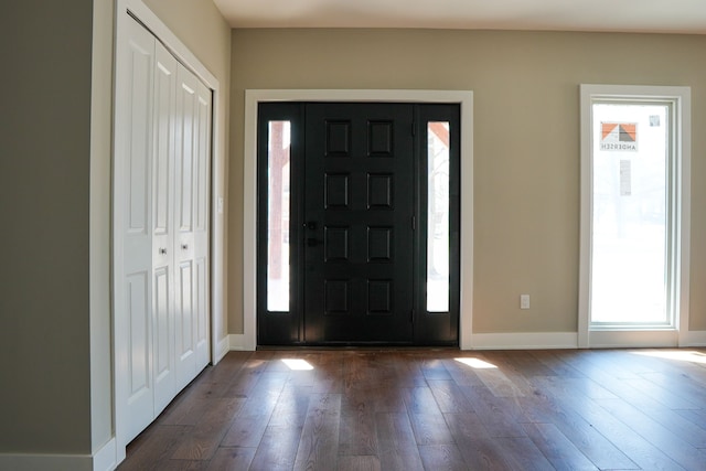 foyer featuring dark wood-type flooring and baseboards