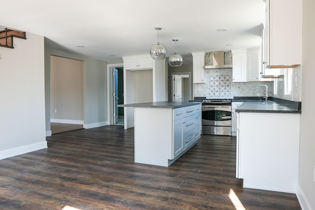 kitchen featuring dark countertops, electric range, white cabinets, and wall chimney range hood