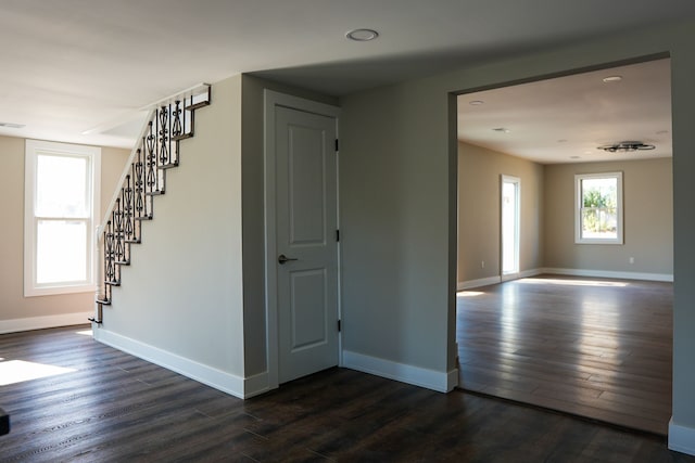 interior space featuring baseboards, dark wood-type flooring, and stairs