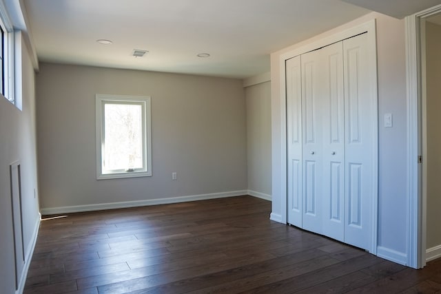 unfurnished bedroom with visible vents, dark wood-type flooring, recessed lighting, a closet, and baseboards