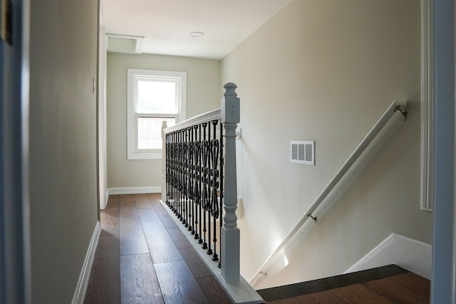 staircase featuring visible vents, baseboards, and wood-type flooring