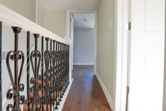 corridor featuring dark wood finished floors and baseboards