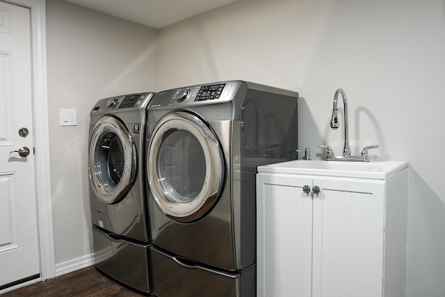 washroom with cabinet space, dark wood-style floors, washing machine and dryer, and baseboards