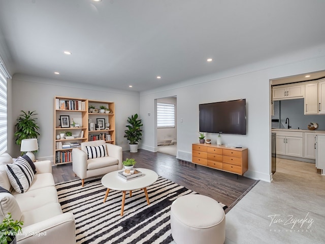 living room featuring recessed lighting, light wood-type flooring, baseboards, and visible vents