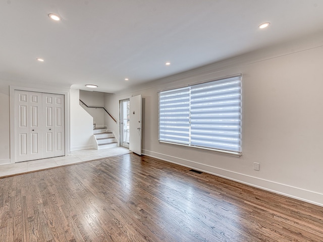 interior space featuring visible vents, wood finished floors, recessed lighting, baseboards, and stairs