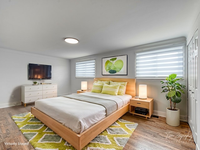 bedroom featuring a closet, baseboards, and wood finished floors