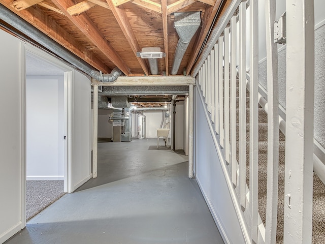 unfinished below grade area with stairs, visible vents, heating unit, and water heater