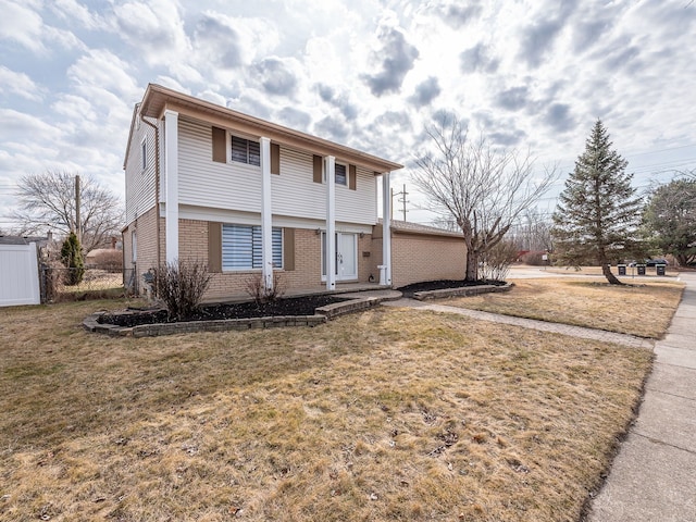 view of front of home featuring brick siding, a front yard, and fence