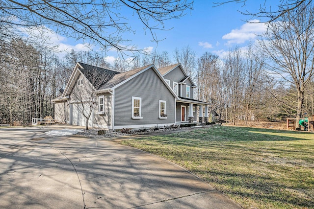 view of property exterior featuring driveway, an attached garage, covered porch, a playground, and a lawn