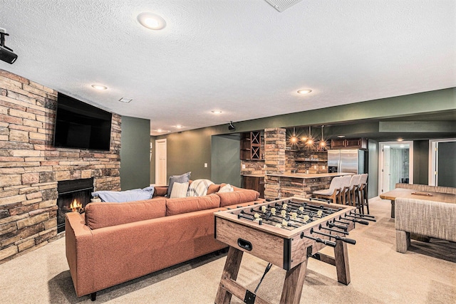 living room with light carpet, a textured ceiling, recessed lighting, a bar, and a fireplace