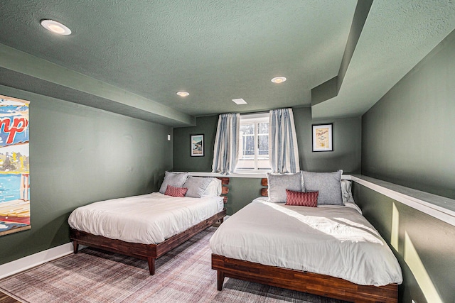 bedroom with recessed lighting, baseboards, and a textured ceiling