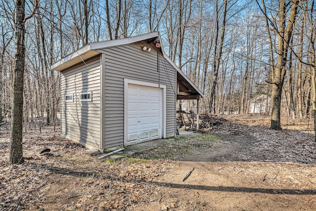 detached garage featuring dirt driveway