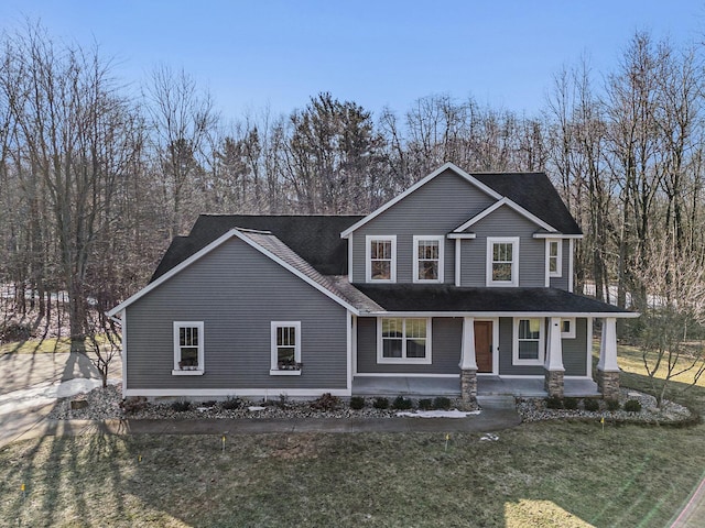 view of front of home featuring a front lawn, a porch, and a shingled roof