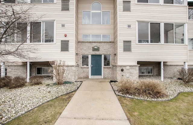 doorway to property featuring brick siding