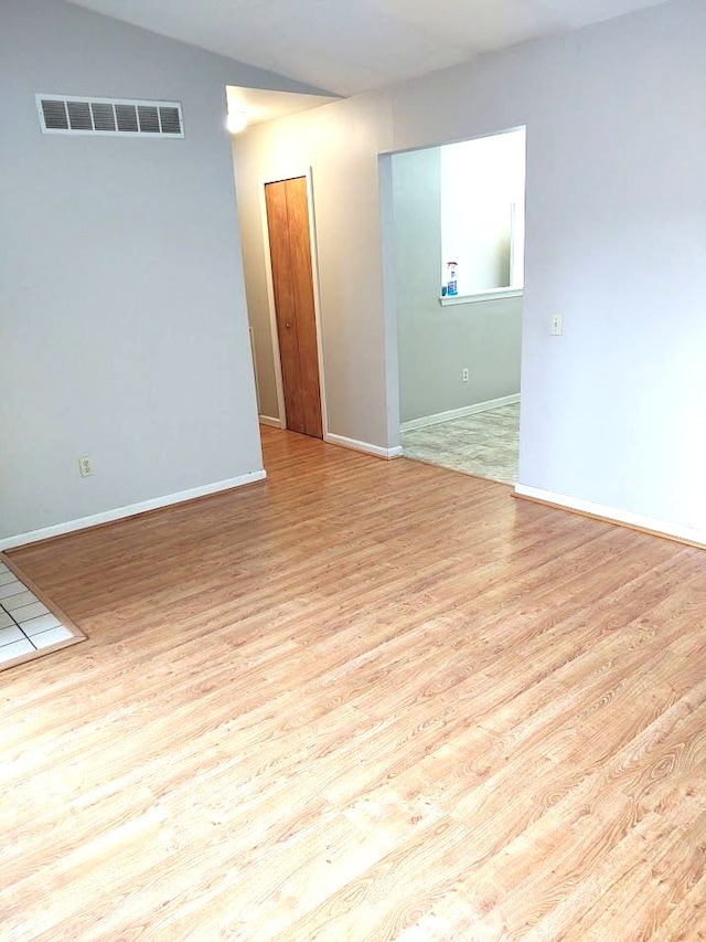 21641 Jacksonville St, Farmington Hills, MI 48336 - empty room with vaulted ceiling, visible vents, baseboards, and wood finished floors