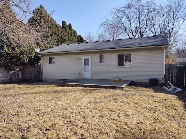 back of property featuring central AC unit, a lawn, a deck, and fence