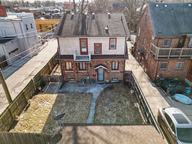 back of property with brick siding and a fenced backyard