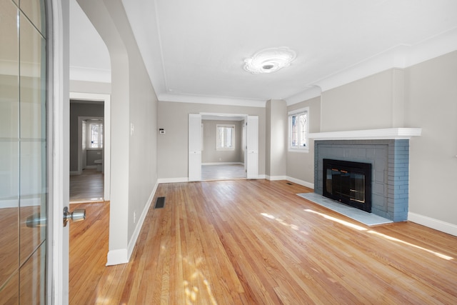 unfurnished living room featuring baseboards, visible vents, and light wood finished floors