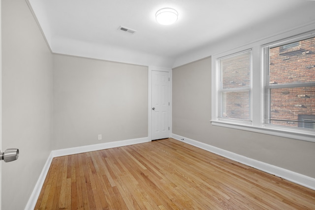 unfurnished room featuring visible vents, baseboards, and light wood-style flooring