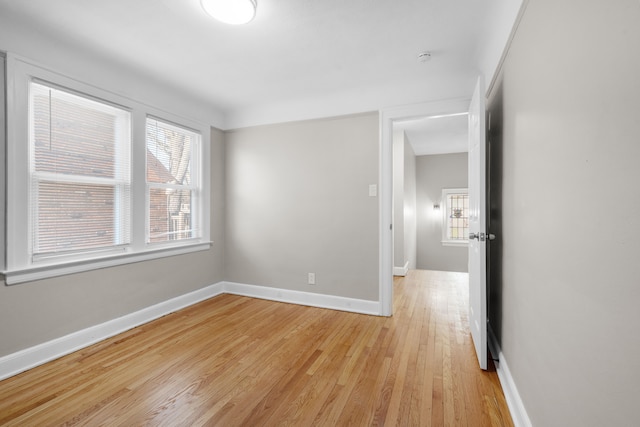 empty room featuring baseboards and light wood-style flooring