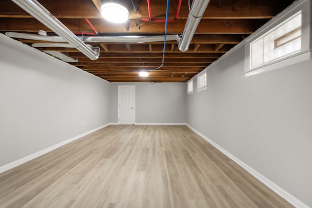 below grade area with baseboards and wood finished floors