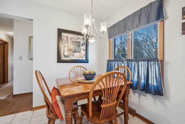 dining room with light tile patterned floors, a notable chandelier, and baseboards