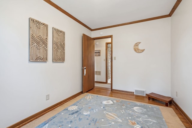 empty room featuring baseboards, visible vents, and ornamental molding