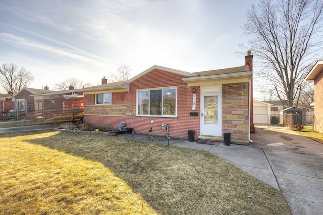 view of front facade featuring a front yard, brick siding, a chimney, and fence