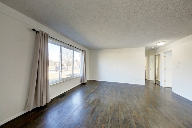 unfurnished room with visible vents, a textured ceiling, baseboards, and dark wood-style flooring