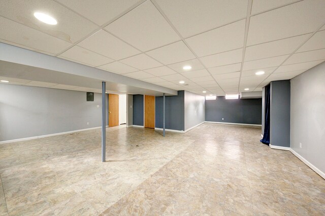 finished basement with recessed lighting, baseboards, and a paneled ceiling