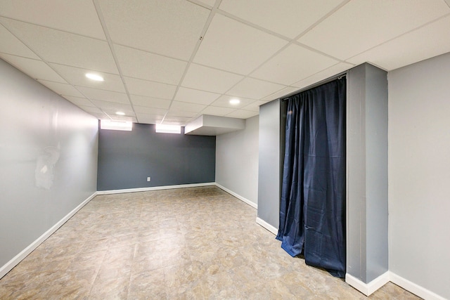 empty room featuring recessed lighting, a drop ceiling, and baseboards