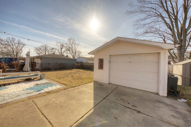 detached garage with driveway and fence