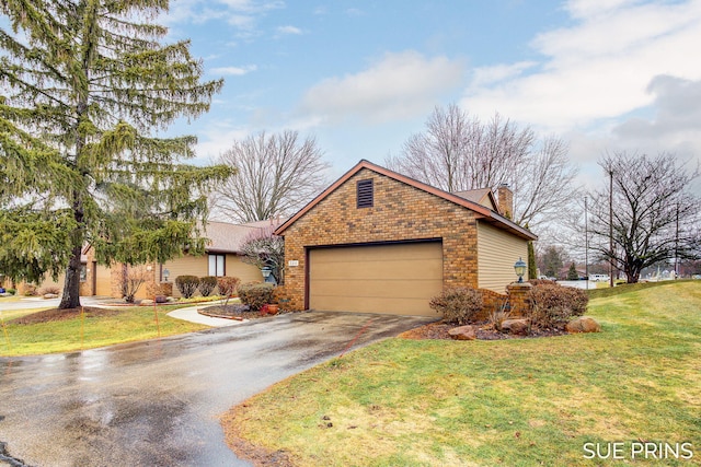 view of front of property with brick siding, a front lawn, a chimney, a garage, and driveway