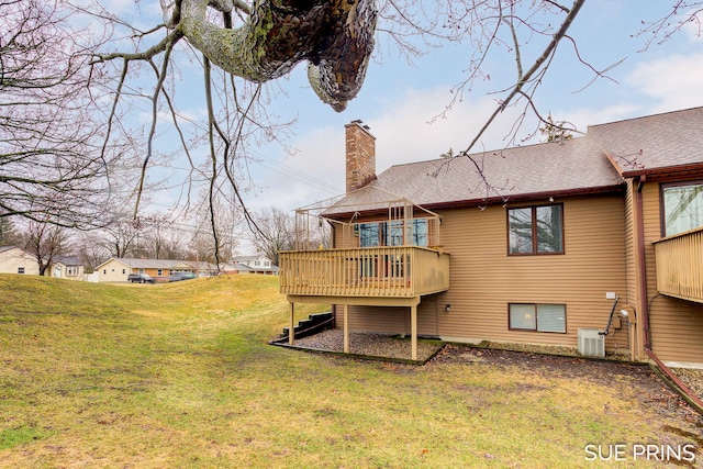 back of house with roof with shingles, a yard, a chimney, a deck, and central air condition unit