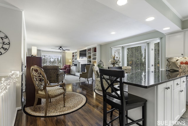 kitchen featuring dark wood-type flooring, a breakfast bar area, and white cabinets