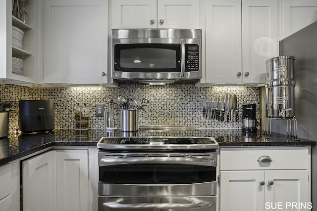 kitchen with tasteful backsplash, dark stone counters, stainless steel appliances, white cabinetry, and open shelves