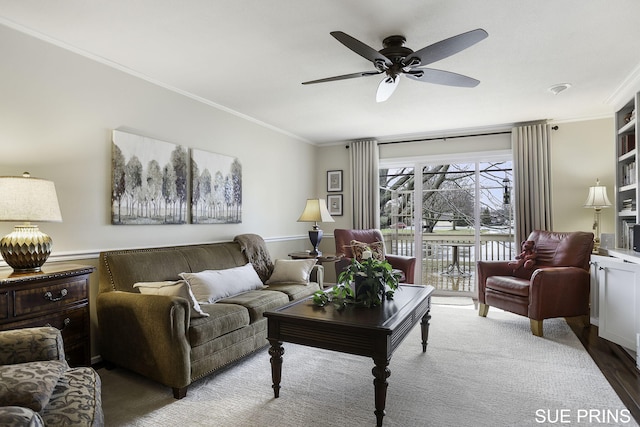 living area featuring crown molding, ceiling fan, and wood finished floors