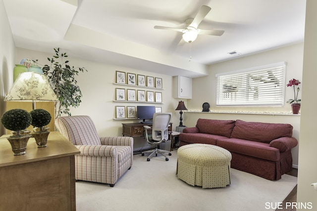 living area with light carpet, visible vents, and ceiling fan