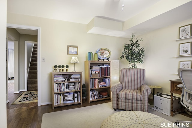 sitting room with stairway, baseboards, and wood finished floors