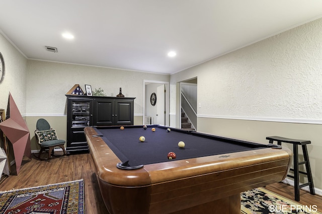 game room with visible vents, dark wood-style floors, pool table, crown molding, and a textured wall